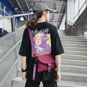 Détail d'un sac bandoulière en nylon violet foncé avec large sangle sur un mannequin