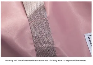 Detail of X-shaped reinforced stitching and double seams on the pink travel bag handle