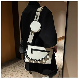 Detail of contrast black and white crossbody bag set with wide strap and chain