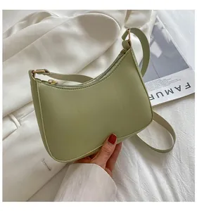 Detail view of light green PU leather half-moon bag with smooth zipper and golden hardware