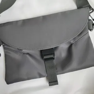 Détail de la sacoche en nylon gris imperméable avec boucle noire et bandoulière tissée