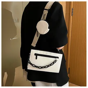 Detailed view of white crossbody bag with black chain and mini round coin purse