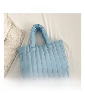 Vue détaillée du sac cabas matelassé bleu clair avec texture douce et coutures verticales