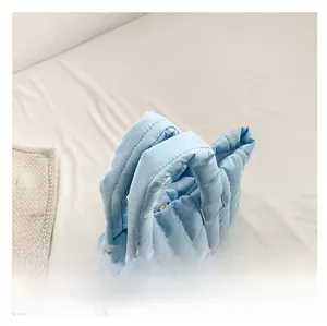 Détail du sac cabas matelassé bleu clair en nylon avec poignées épaisses et bouton