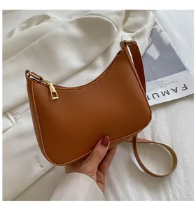Close-up of caramel brown hobo bag featuring fine litchi grain and gold zipper detail
