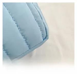 Gros plan détaillé du tissu en nylon matelassé bleu clair avec coutures régulières