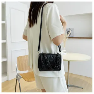Fashionable black quilted shoulder bag featuring a chunky acrylic chain and sleek flap design
