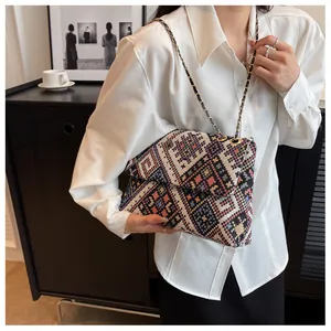 Detail of colorful geometric woven fabric and gold chain strap on a tote bag