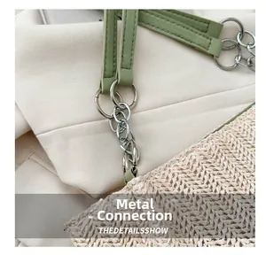 Close-up of the silver metal chain connection on a beige straw bucket tote bag