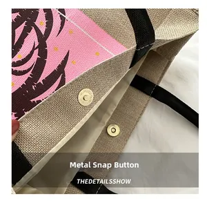 Detail of the magnetic snap closure on the printed jute tote bag with black strap