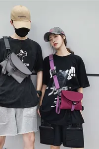 Détail de sacs bandoulière en nylon gris foncé et magenta avec larges sangles réglables