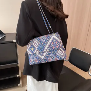 Bohemian style woven shoulder bag with geometric patterns and golden chain strap