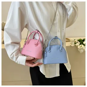 Close-up of mini litchi pattern shell bags in pink and blue with metal bead chains