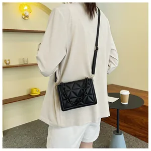 Detail view of black quilted crossbody bag with thick acrylic chain on a model