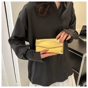 Detail shot of a fashion gold metallic clutch purse with a glossy mirror-like finish