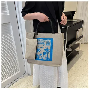 Fashionable beige canvas tote bag with blue palm tree print and matching small pouch