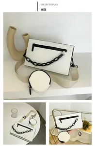 Detail view of off-white rectangle crossbody bag with mini pouch and black chain decor