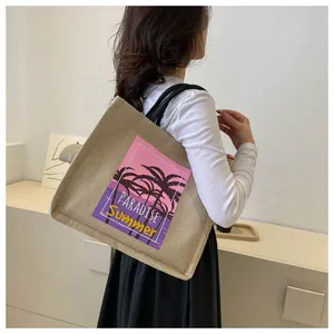 Detail of canvas tote bag featuring Paradise Summer tropical print and black shoulder strap