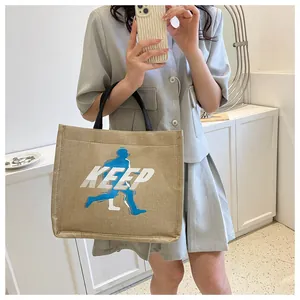 Asian model holding beige canvas tote bag with KEEP print and black handles for daily use