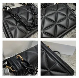 Detail of black quilted crossbody bag featuring resin chain and gold hardware