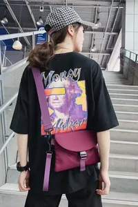 Détail de la sacoche bandoulière violette foncée avec boucle noire et imprimé t-shirt