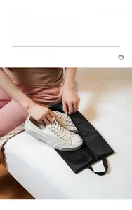 Detail of black mesh travel shoe bag with metal zipper and handle holding canvas shoes