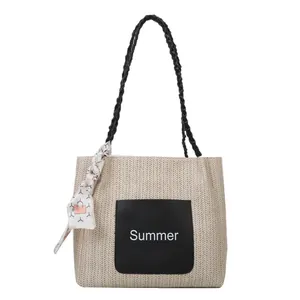 Sac fourre-tout d'été en paille avec anses noires et détail de foulard en soie
