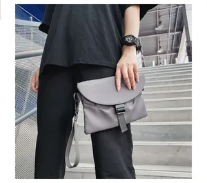 Gros plan d'une sacoche en nylon gris avec boucle noire sur un escalier métallique