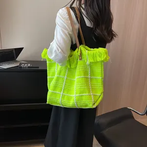 Neon yellow woven tote bag with white grid pattern and stylish fringe detailing