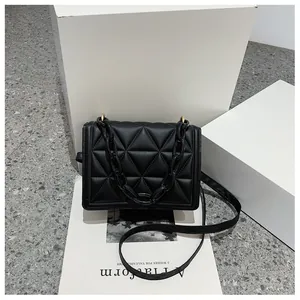 Detail view of the black quilted texture with triangle stitching and thick acrylic chain