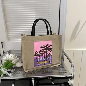 Linen tote bag with tropical paradise print and black handles on a stylish metal cart