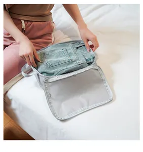 Grey mesh travel organizer bag with handle showing capacity for folded denim jeans
