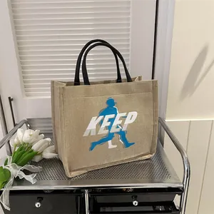 Minimalist beige jute tote bag with KEEP logo and blue runner silhouette on metal shelf