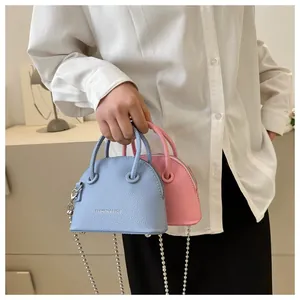 Macro detail of lychee grain leather mini shell bags in sky blue and pink colors