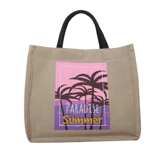 Natural jute summer tote bag with black handles and paradise palm tree graphic print