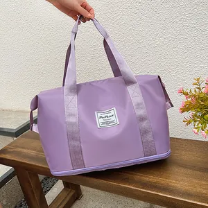 Detail of purple travel bag with reinforced handles and expandable bottom zipper