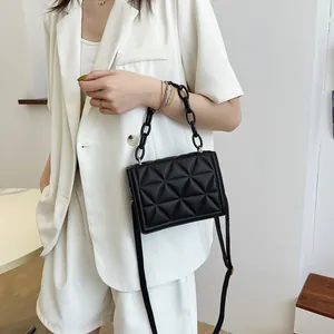 Black quilted crossbody bag with chunky acrylic chain handle and minimalist design