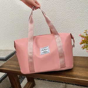 Detailed shot of pink travel bag with woven label and separate bottom compartment