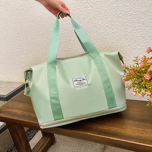 Detail view of the light green travel bag with separate bottom zipper compartment for shoes