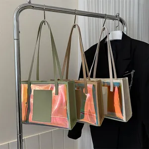 Three holographic laser PVC tote bags in green, coffee and cream hanging on a rack