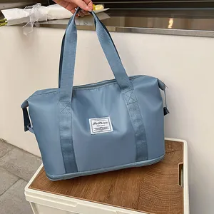 Detail view of large blue travel bag with bottom compartment and waterproof fabric texture