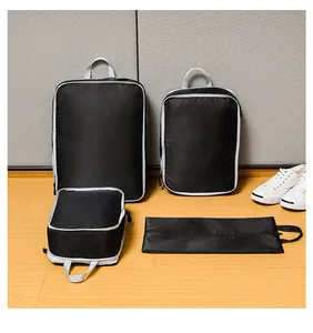 Detail of four black travel organizer bags with honeycomb texture on wooden floor