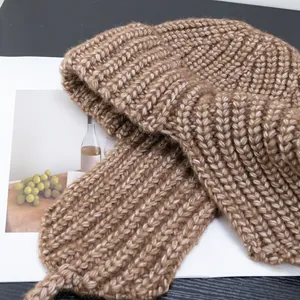 Detail of coffee brown ribbed knit beanie showing thick warm wool texture on magazine