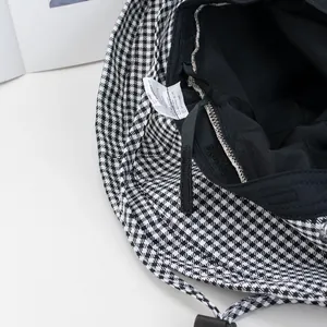 Black and white houndstooth bucket hat with adjustable inner strap and premium lining