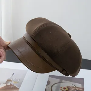 Close-up of brown newsboy hat showing knit texture and PU leather brim detail