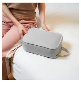Close-up of grey mesh travel storage bag with handle and zipper on white bedding