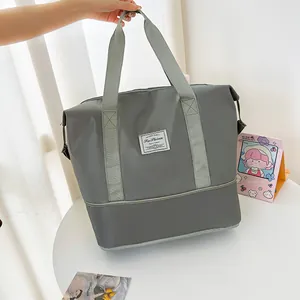 Large grey travel bag with expandable bottom and waterproof nylon for fitness and sports