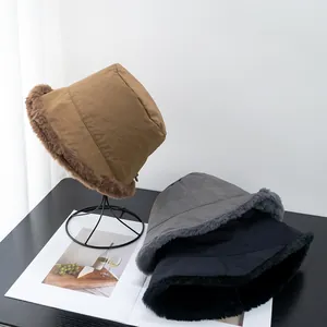 Close-up of thick winter bucket hats with plush faux fur lining in brown, grey and black