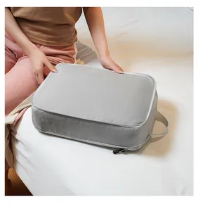 Light gray waterproof travel organizer bag shown during packing on a white bed