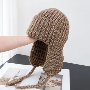 Detailed texture of brown knit trapper hat with thick ribbing and ear flaps